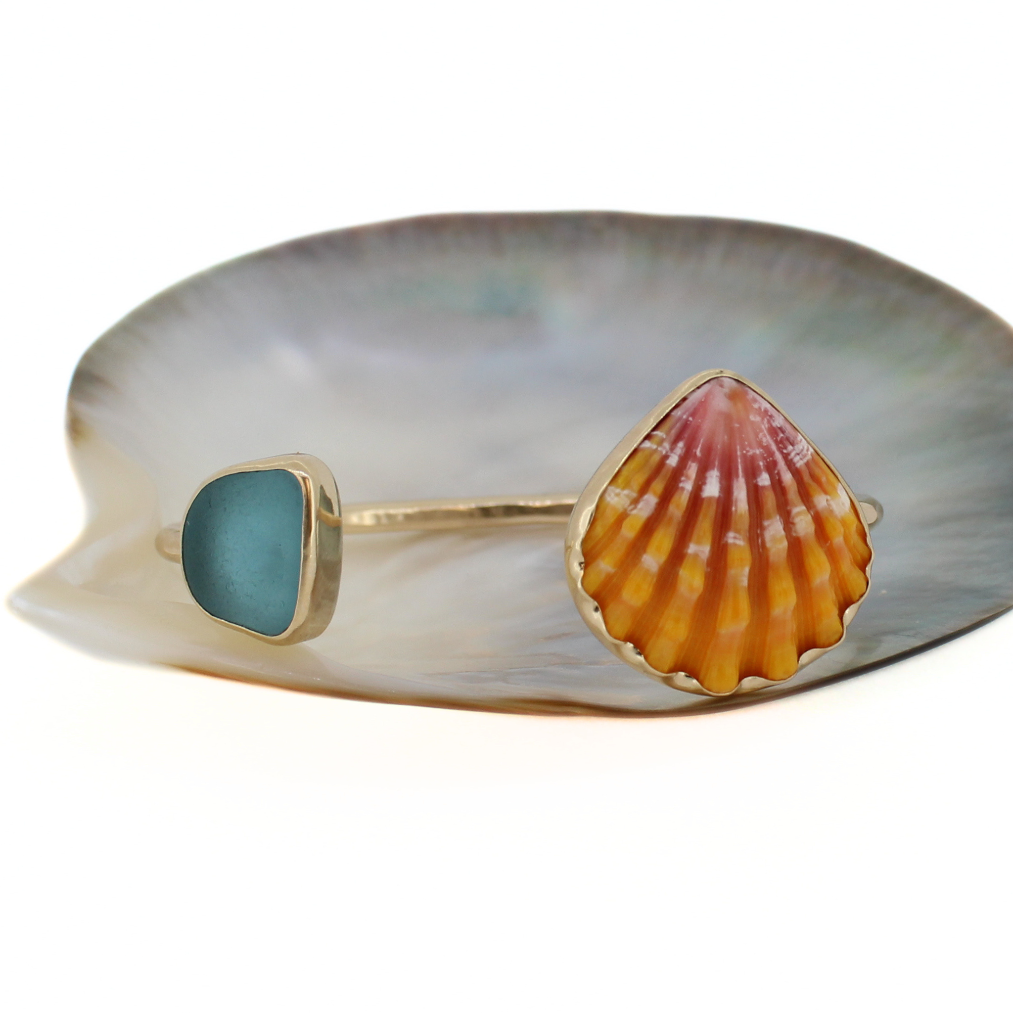 Gold cuff bracelet with teal sea-glass square and orange sunrise shell centerpiece
