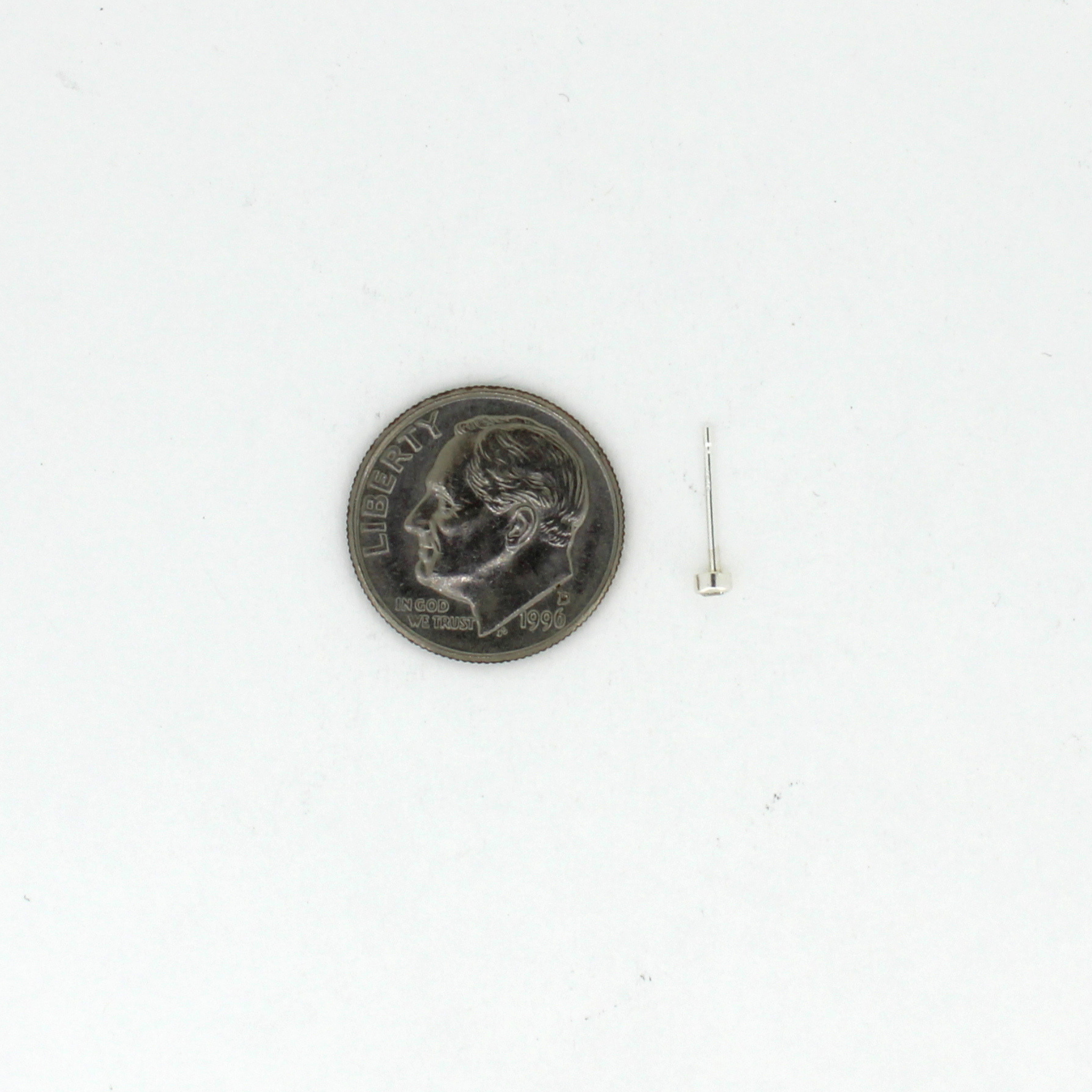Tiny silver stud earring next to a dime for size reference 