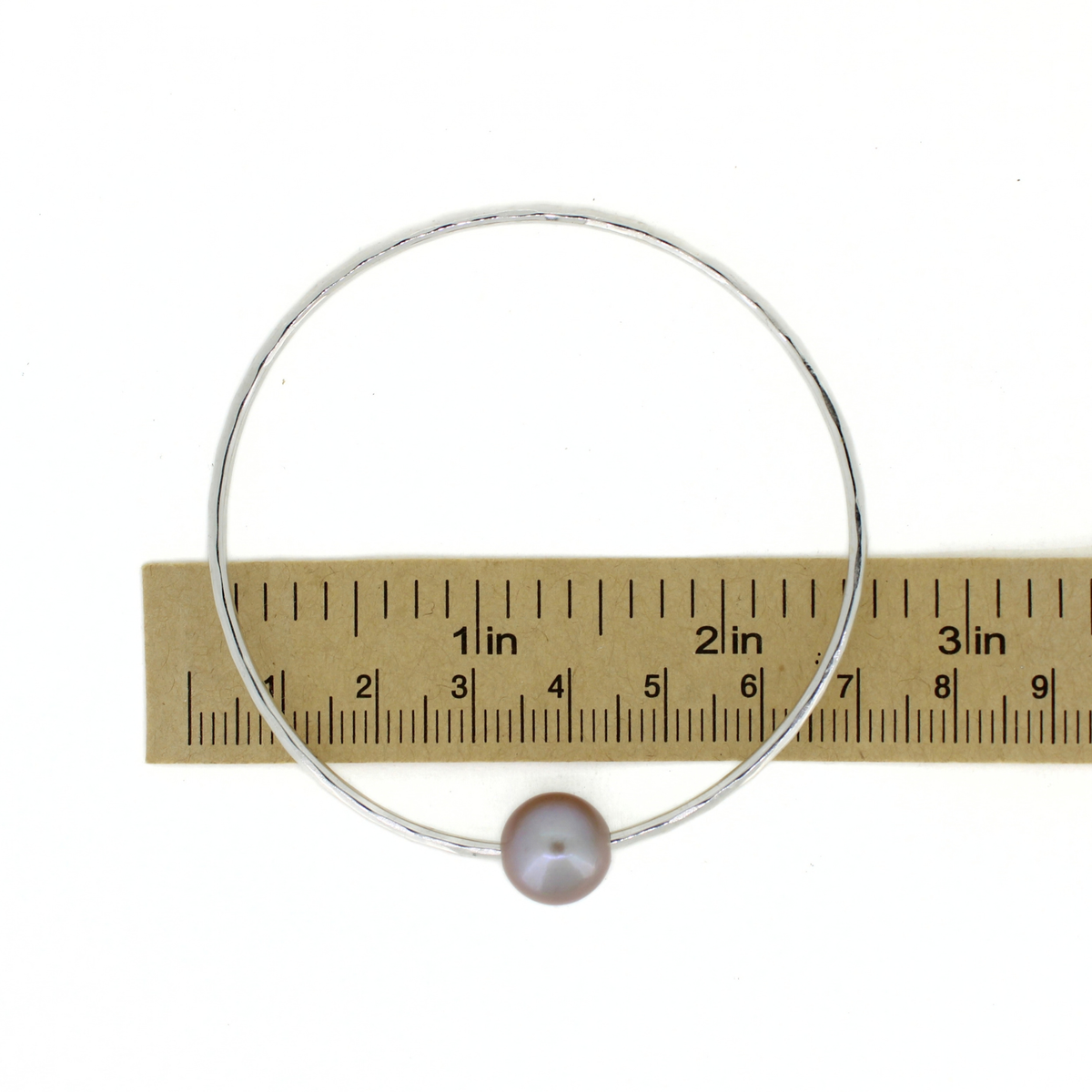Silver round Edison pearl bangle shown over a ruler for size reference 