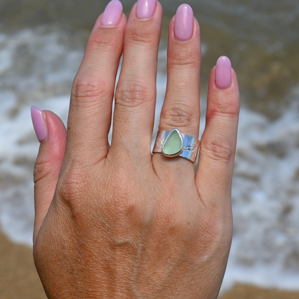 Sterling silver bezel set sea glass ring with wide puakenikeni flower stamped band size 6 handmade by Brianne & Co.