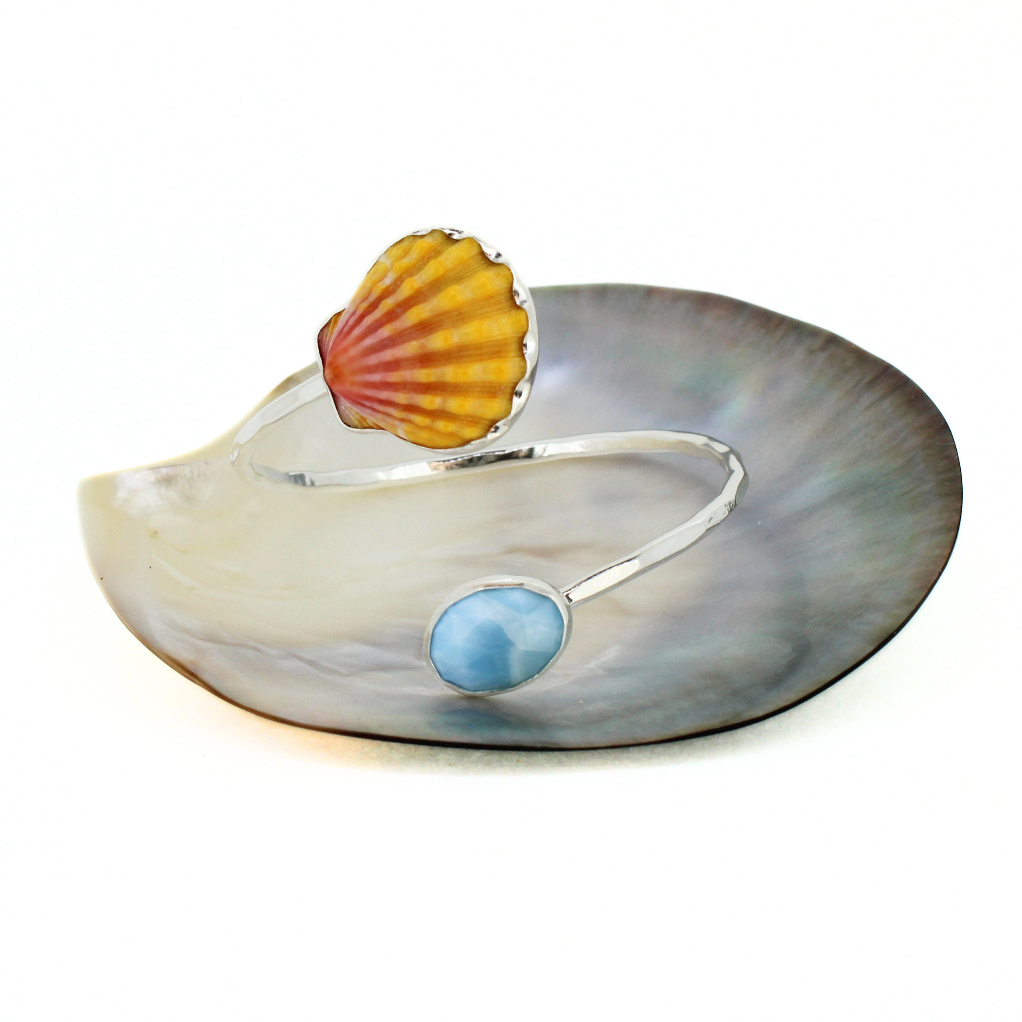 Sterling silver bypass cuff with shell top and blue oval larimar on wide curved band