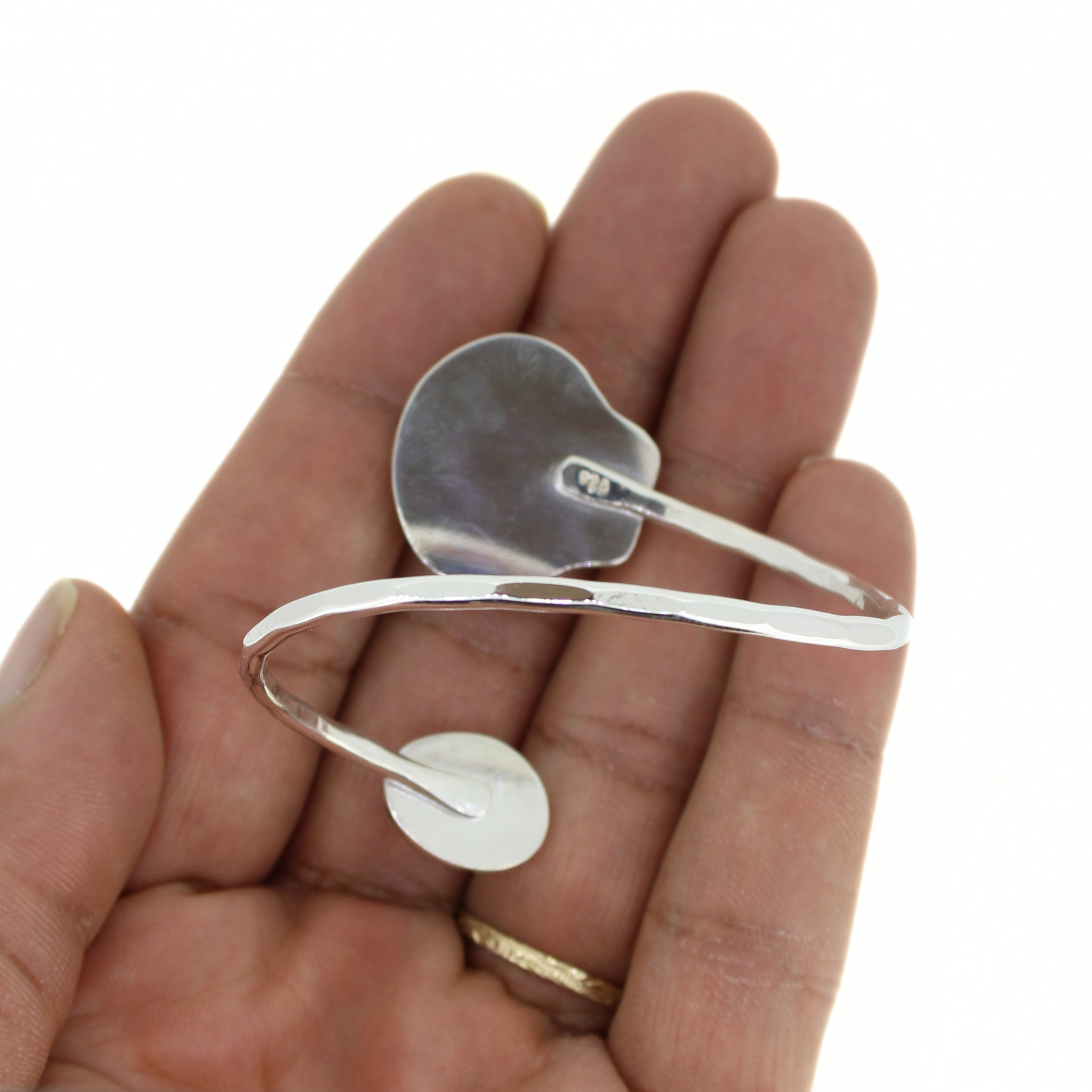 Sterling silver bypass cuff with smooth underside and setting on curved open band