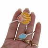 Brianne & Co. sterling silver sea glass and sunrise shell cuff bracelet on hand for size reference