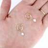 Brianne & Co dainty pearl and gold hoop earrings shown in hand