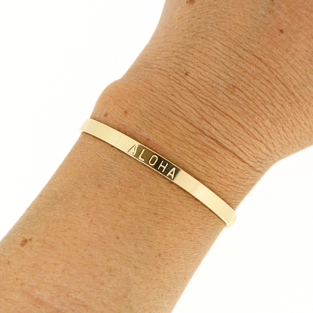 Brianne and Co Gold Fill ALOHA Stamped Cuff on a wrist