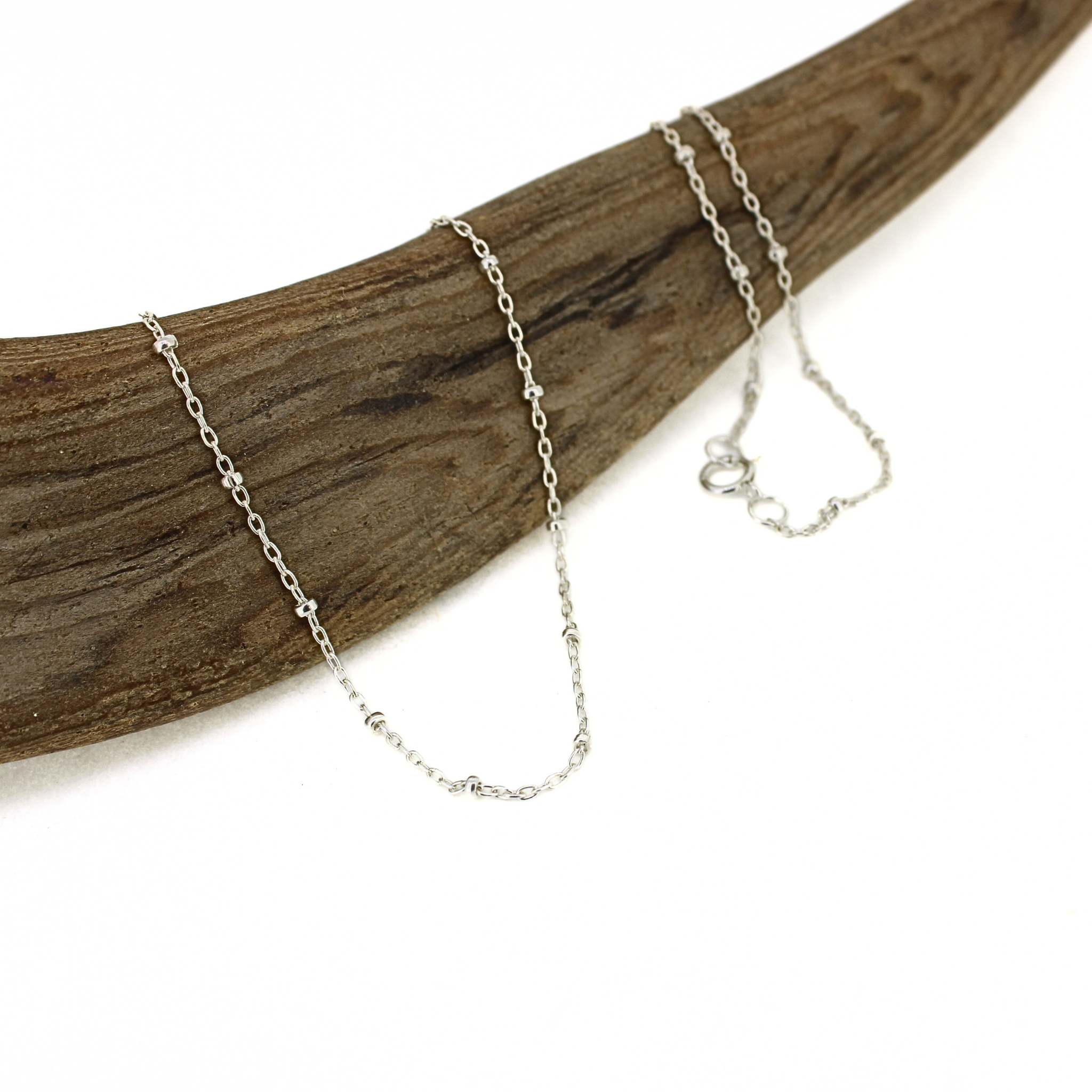 Brianne and Co. Sterling Silver Satellite Chain w/ 2mm beads on piece of wood 