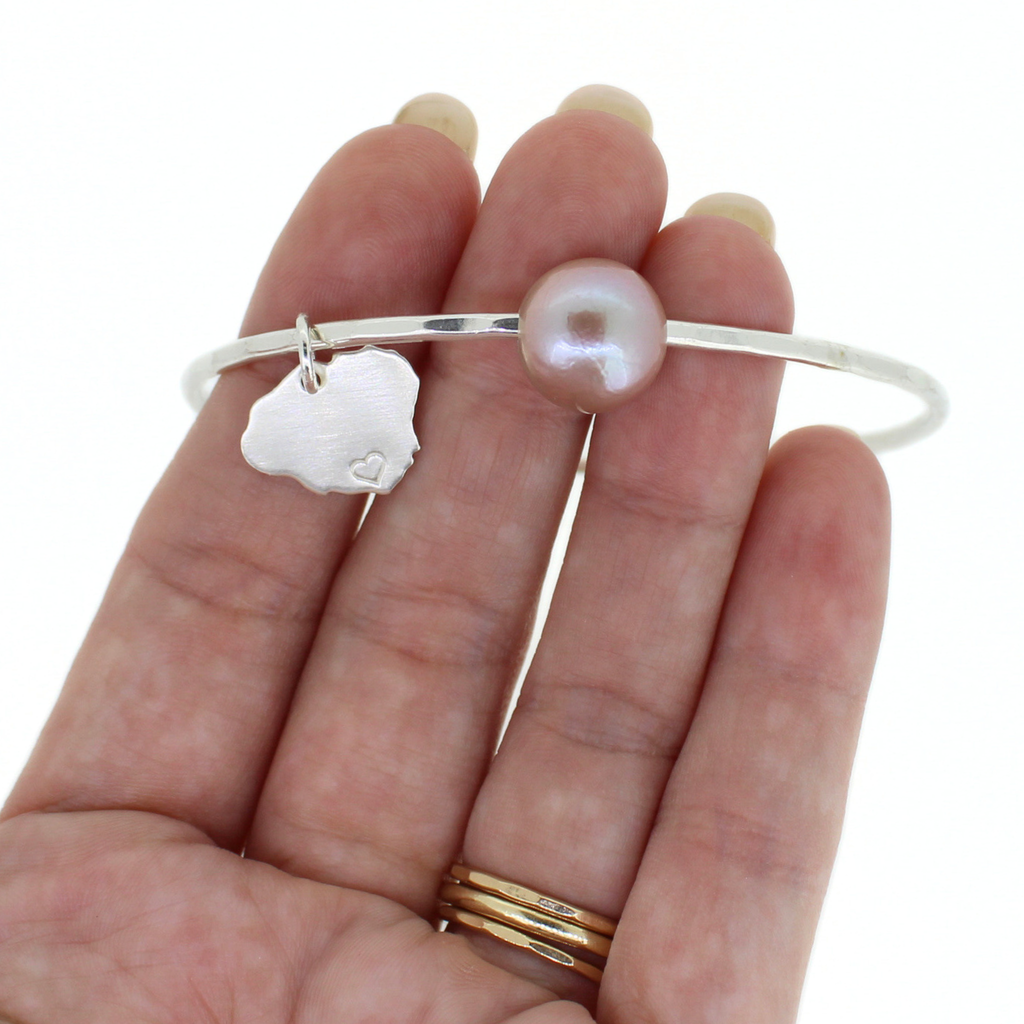 Brianne & Co. sterling silver pink fresh water Edison pearl bangle with Kauai charm on hand for size reference