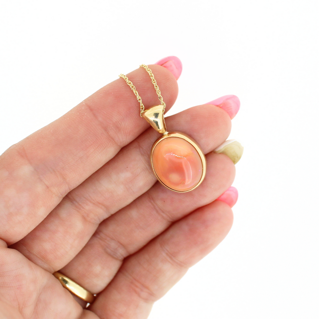 Brianne & Co. 14k gold bezel set pink Mexican fire opal necklace on hand for size reference