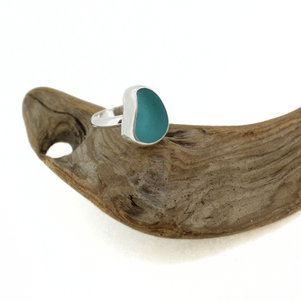 Brianne and Company Sterling Silver Blue Sea Glass Ring w/ Wave Design Size 8 on a piece of wood