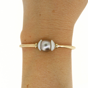 Brianne and Co gold fill tahitian pearl and puka shell cuff on a wrist