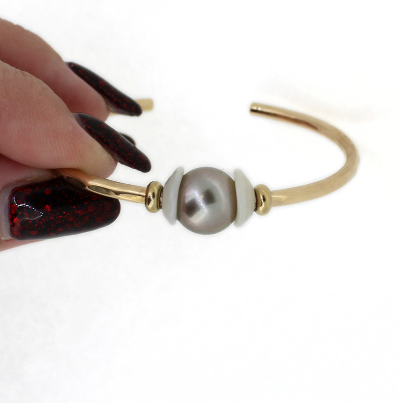 Brianne and Company gold fill tahitian pearl and puka shell cuff being held