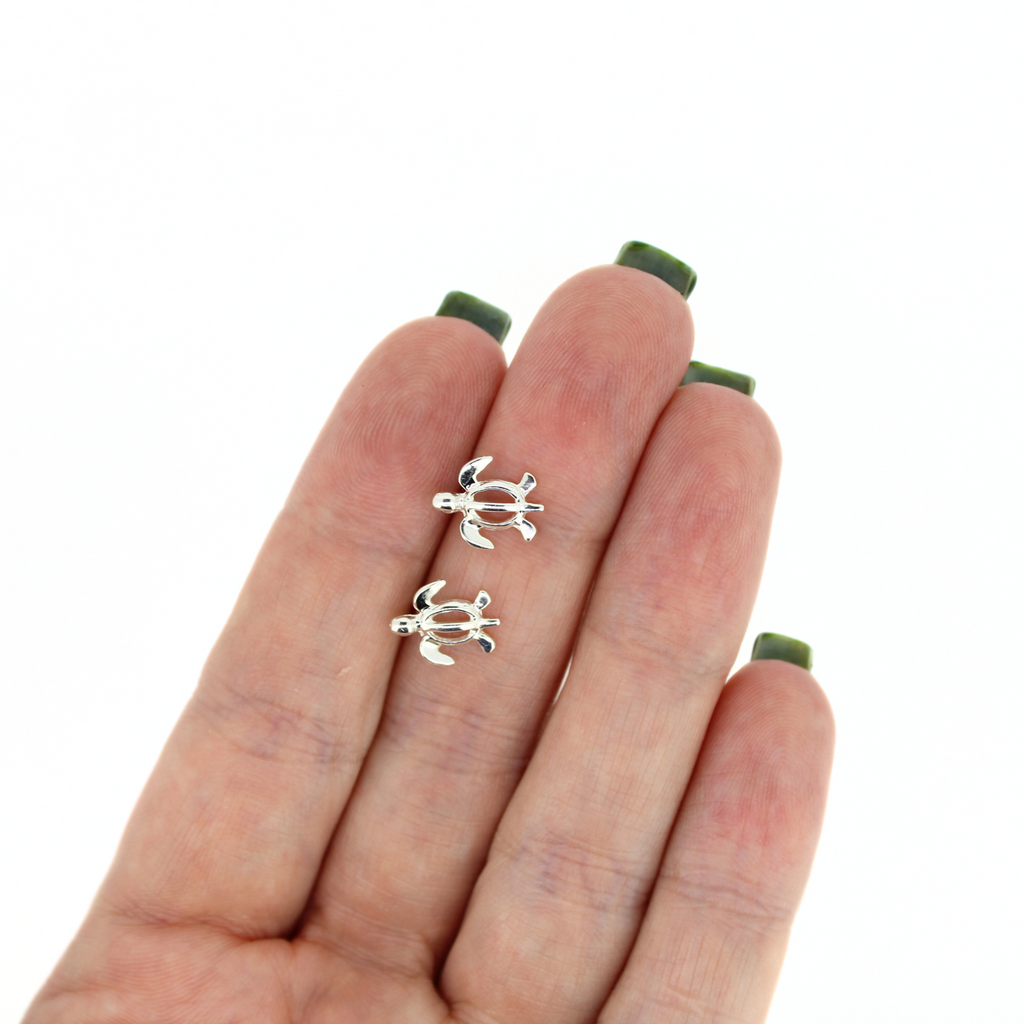 Brianne & Co sterling silver sea turtle stud earrings shown in hand
