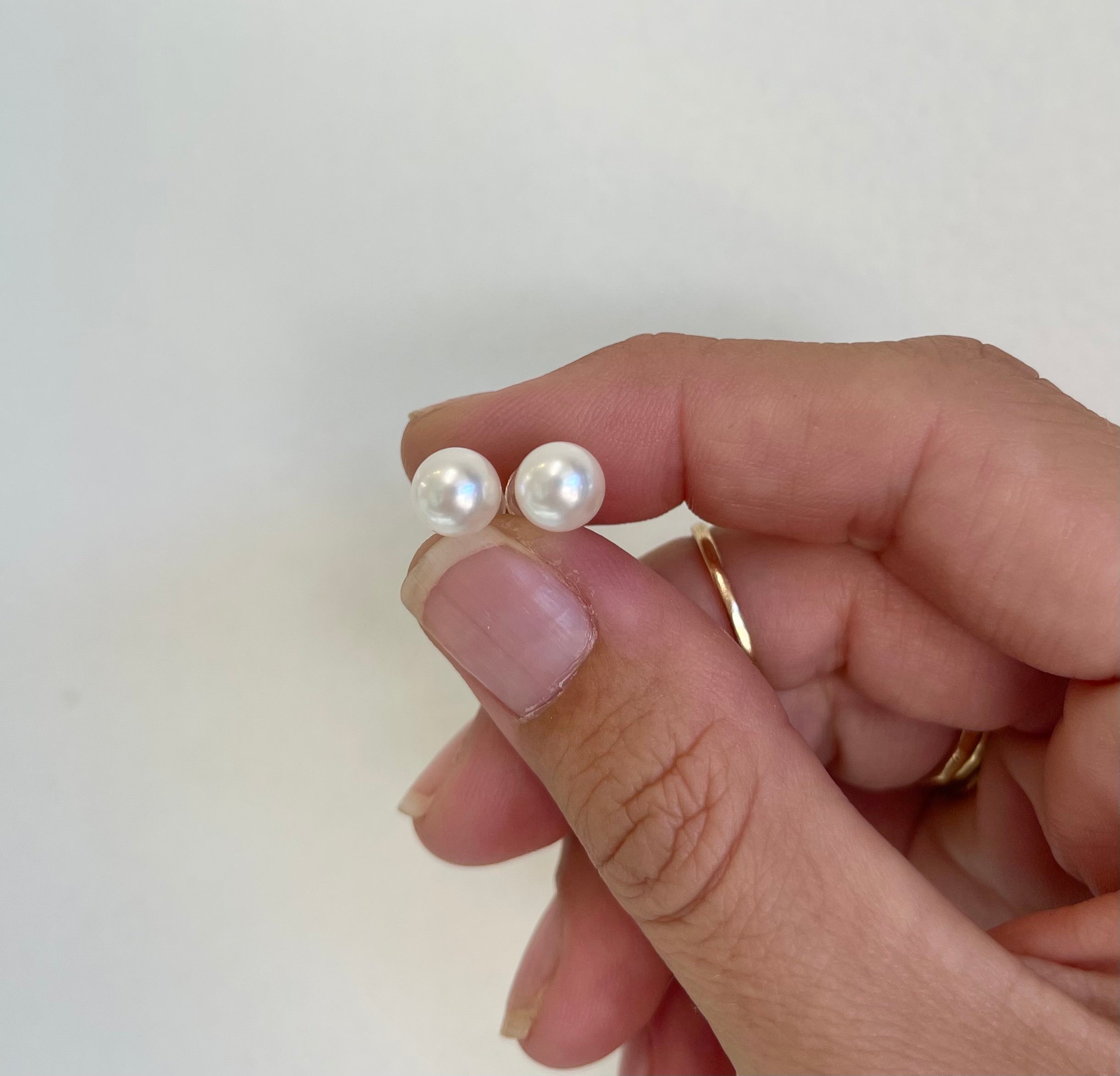 Pearl stud earrings with two white round pearls and gold posts