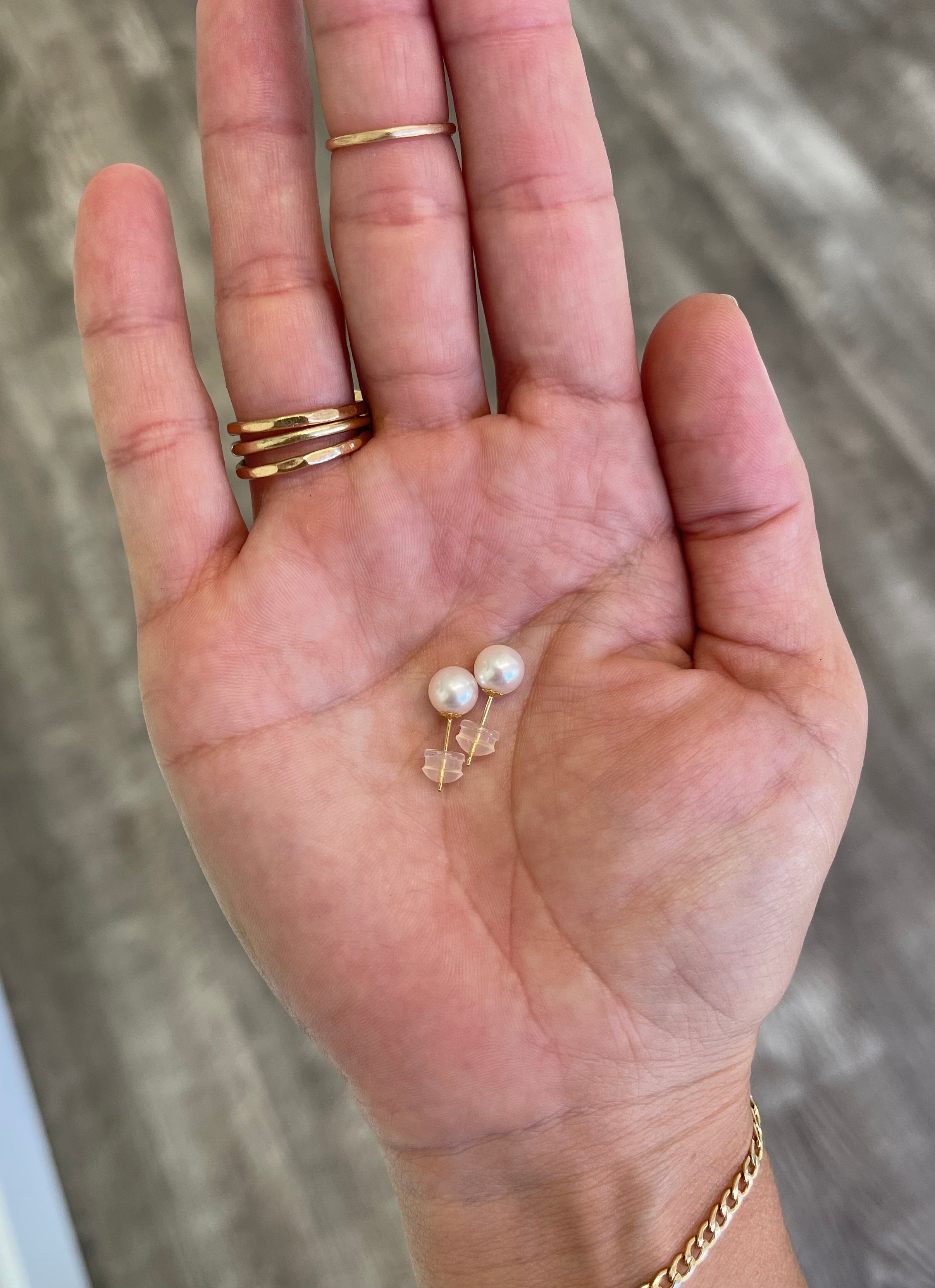 Gold pearl stud earrings with two white round pearls on post setting